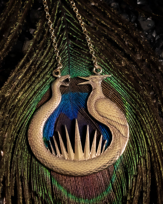 Close-up of the engraved snake and mockingjay detail on the brass pendant