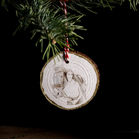 Wooden Christmas ornament with engraved design of a horse and rider, hanging on a tree.