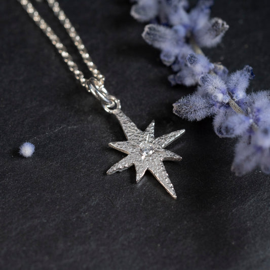 Close-up of the lab white sapphire in the center of the Crescent City inspired pendant