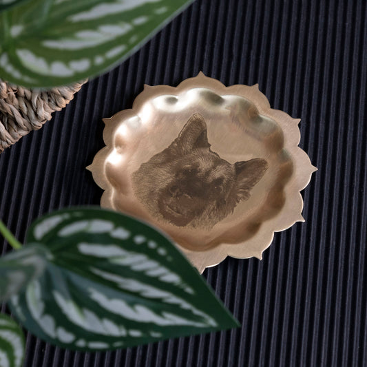 Decorative plate with a dog portrait design on a textured surface with plants.